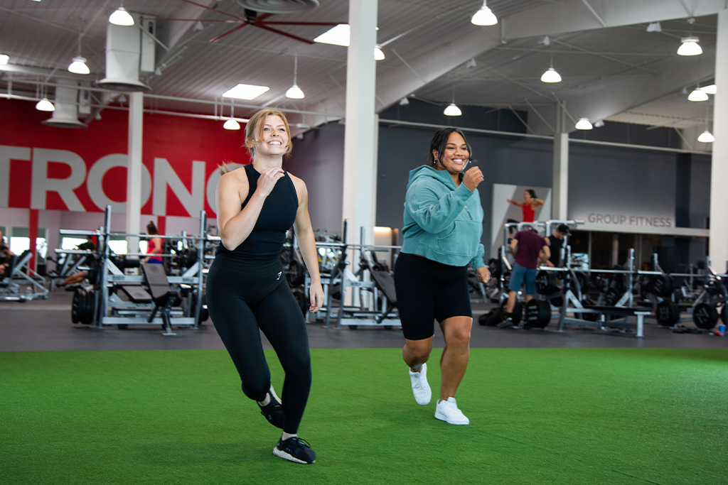 A VASA Gym instructor helping a gym member do a beginner cardio workout