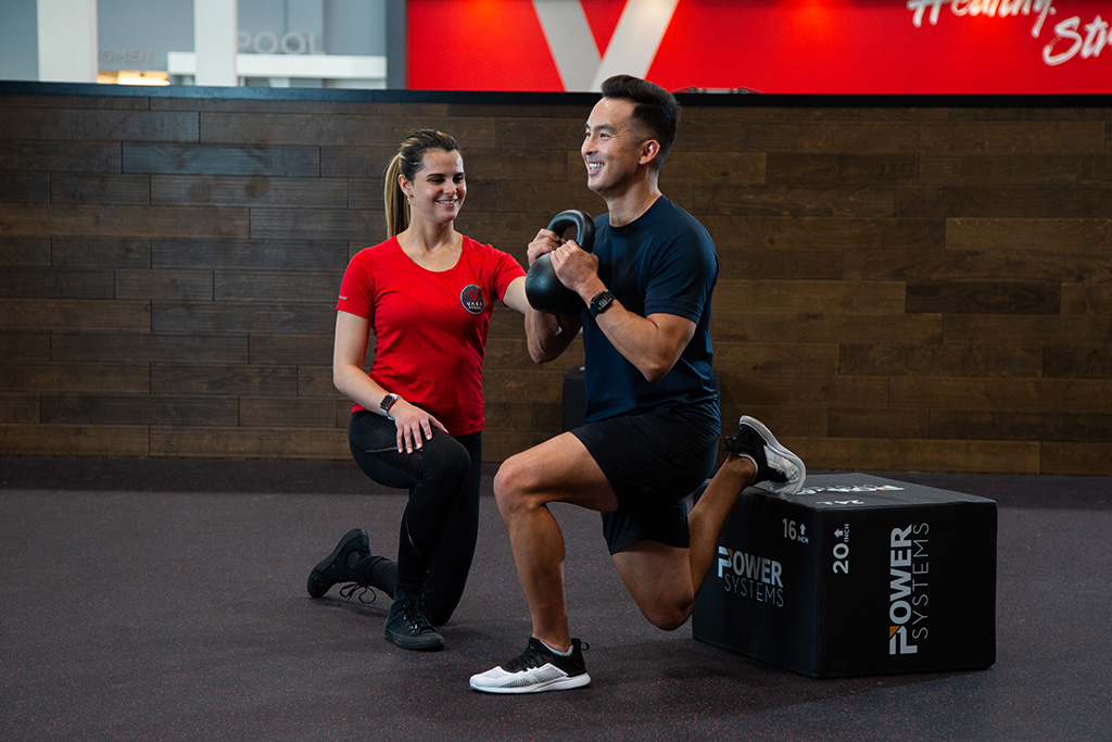 A female private trainer instructing her client through a workout