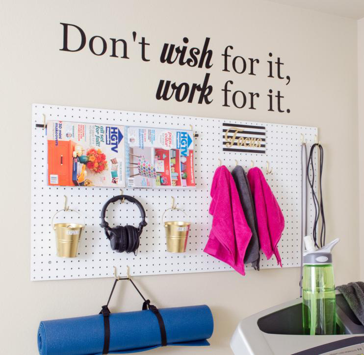 Workout equipment hanging from a peg board used for a home workout space.