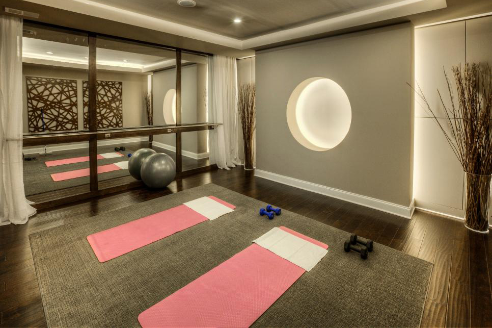 Yoga mats and bells are set up in a home workout space.