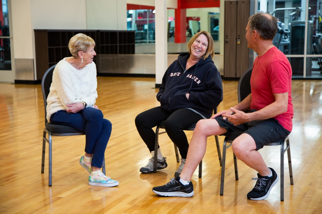 Three seniors sitting next to each other in a VASA gym.