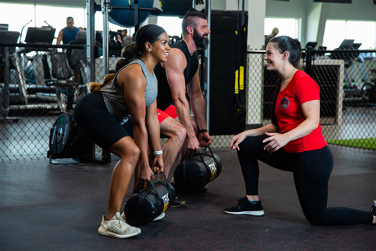 Wellness Reimagined, A personal trainer working with a man and a women at the gym