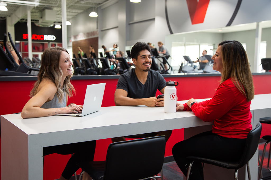 How To Set Workout Goals, two gym members talking with gym staff setting up workout goals