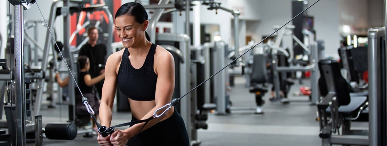 Woman happy using cable machine at local VASA Fitness