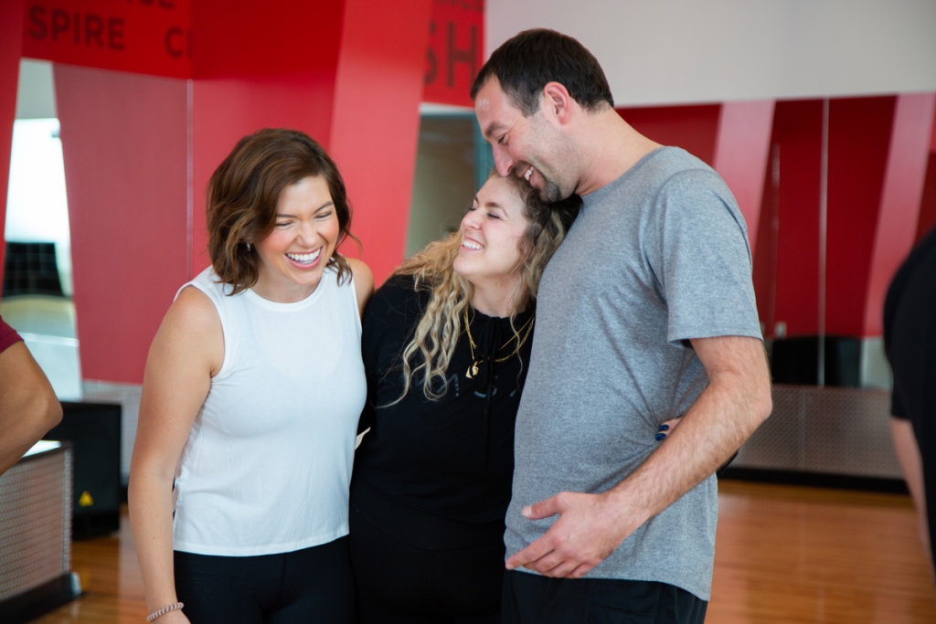 Friends embracing after a group fitness class. Benefits of Group Fitness Classes