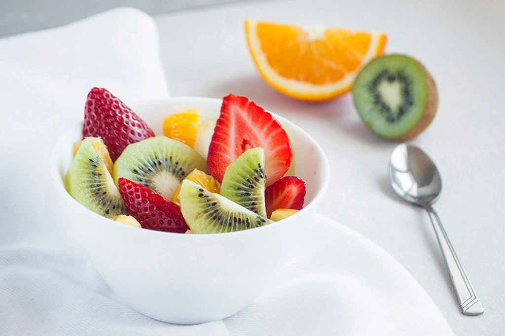 Bowl of fruit, including strawberries, kiwi, and oranges