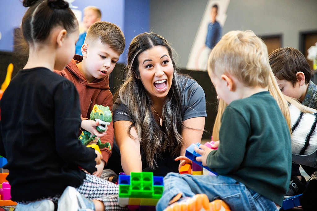 Female VASA employee entertaining a group of children with toys