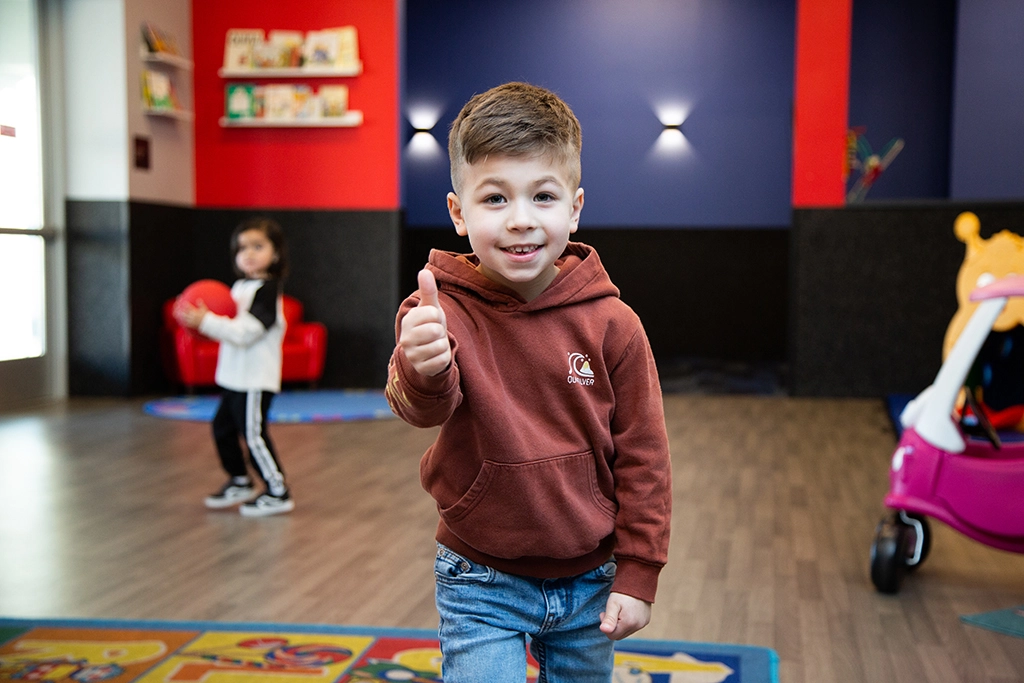 Male child smiling and giving a thumbs up in VASA Fitness KidCare