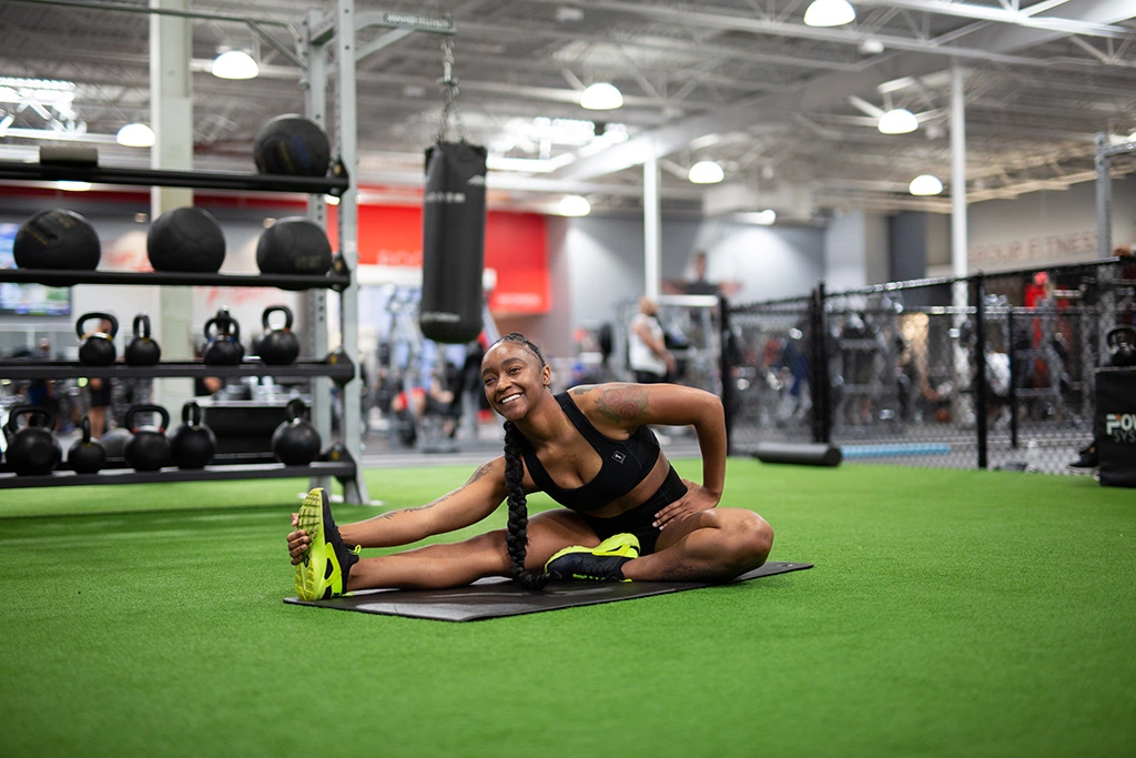 Female athlete doing stretches on turf at VASA Fitness