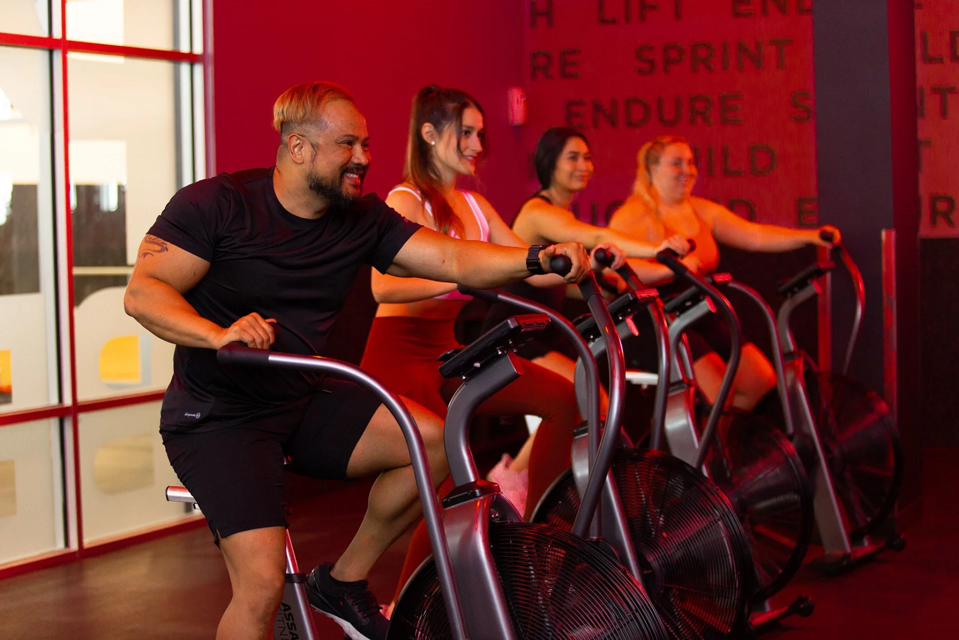 Athletes on air bikes exercising in a group STUDIO RED HIIT class at VASA Fitness
