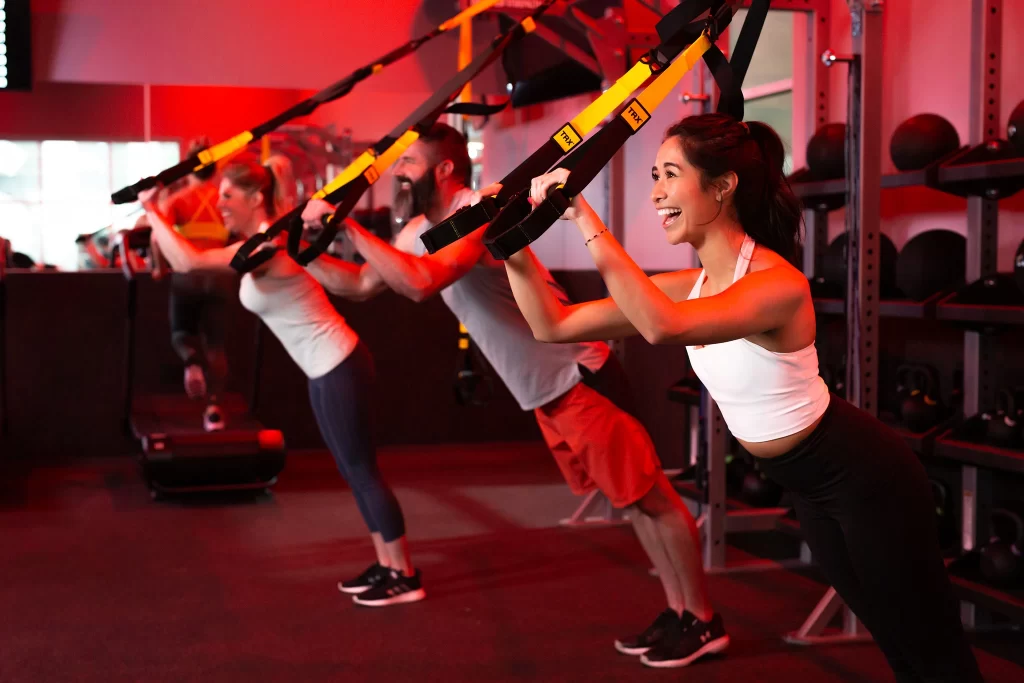 Female athlete doing a TRX workout in a group STUDIO RED HIIT class at VASA Fitness
