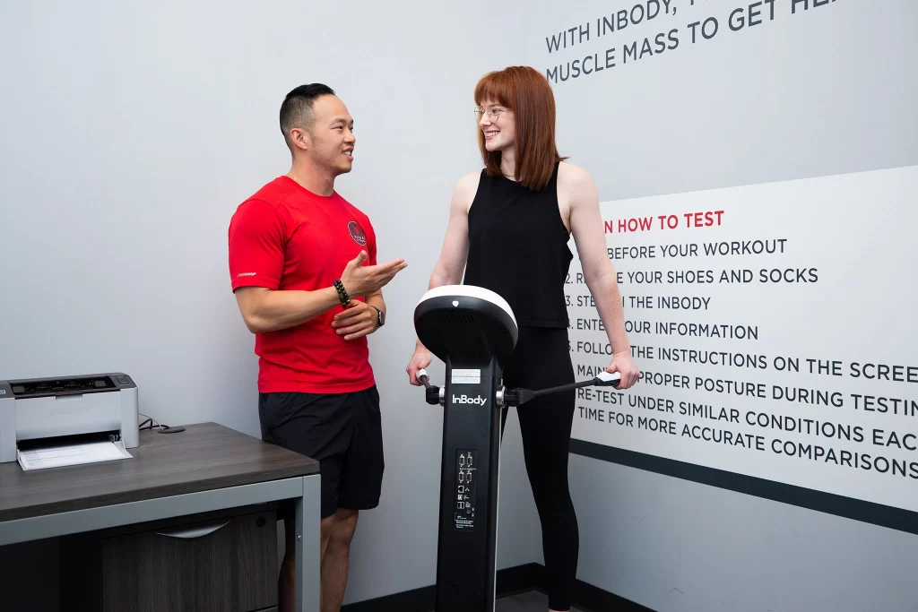 Female athlete with personal trainer doing an InBody Scan at VASA Fitness