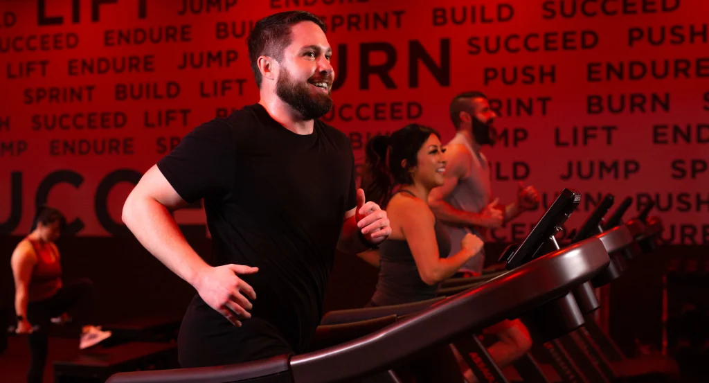 Male athlete running on a treadmill in a group STUDIO RED HIIT class at VASA Fitness