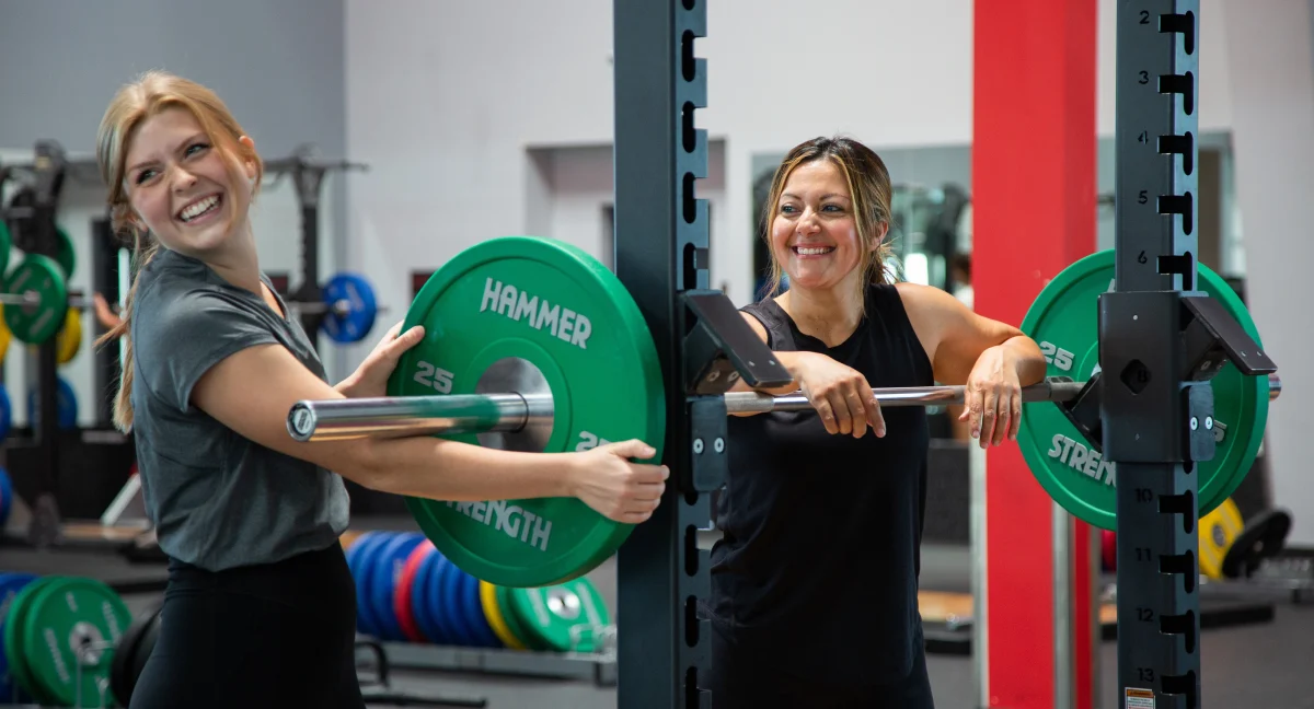 Two female athletes in strength training power lifting area of VASA Fitness